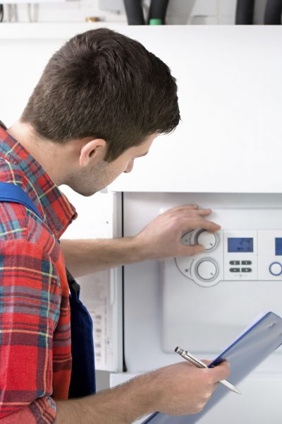 Technician servicing heating boiler
